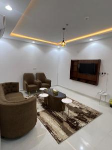 sala de estar con 2 sofás y TV de pantalla plana en شقق برج السمو للشقق المفروشة en Najrán