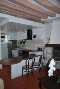 cocina con mesa de madera y sillas en una habitación en Gites aux Fleurs de Cerises, en Le Plessis-Luzarches