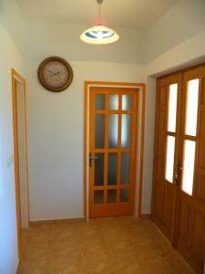een kamer met een deur en een klok aan de muur bij House Fantazija in Rab