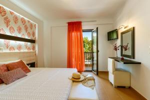 a bedroom with a bed and a chair and a window at 3Aktes Suites & Studios in Syvota +115 photos