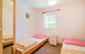 a bedroom with two beds and a mirror at Posejdon Wydmowa 16/2 in Lubiatowo