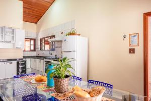a kitchen with a glass table and blue chairs at Refúgio e diversão para FAMÍLIAS a 60 min de SP - Piscina, Churrasqueira, wifi 300Mbps - PETFRIENDLY in Atibaia