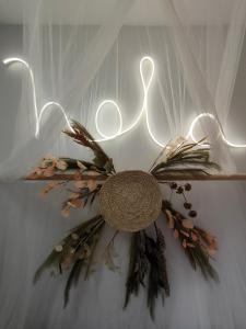 a light up sign with a wreath on a wall at Hola Apartament Alicante in Alicante