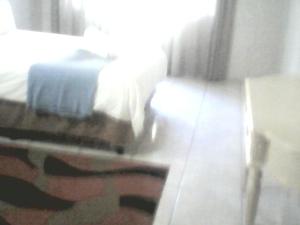 a bedroom with a bed and a table in a room at M AND M HOME FROM HOME in Port Edward