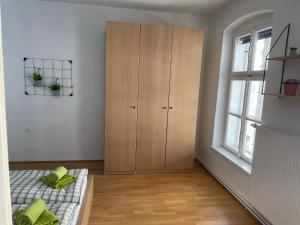 a bedroom with a bed and a cabinet and a window at Ferienapartment Passauer Wolf im Zentrum in Sankt Pölten