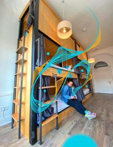 a person sitting in a bunk bed in a room at Leevin Hostel George in Dublin