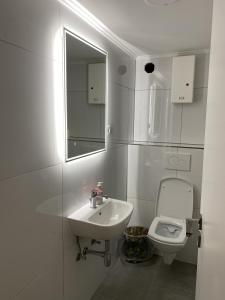 a white bathroom with a sink and a toilet at Kaiserswerth in Düsseldorf
