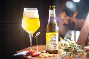 a bottle of beer sitting next to a glass at Långforsen Glamping & Lapland Experience in Haparanda