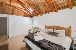 a bedroom with a large bed and a chair at Swallows Nest in Laingsburg +30 photos