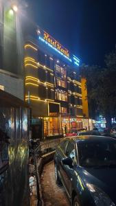 a car parked in front of a building at night at Hotel Manila in Siliguri