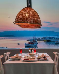 a table with food and wine glasses and a chandelier at Mount Athos Resort in Ierissos