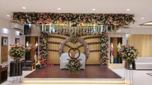 a banquet hall with a wedding altar with flowers at Hotel Manila in Siliguri