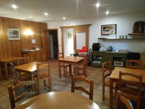 comedor con mesas y sillas de madera en Hostal Cal Mestre en Vilallonga de Ter
