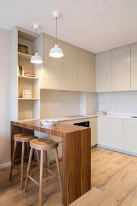 cocina con mesa de madera y taburetes en BLERI Apartment, Near Prishtina Center, Parking available, en Pristina