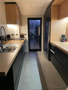 eine Küche mit einem Waschbecken und eine Tür zu einem Flur in der Unterkunft Orchard Lodge Wanaka - Relax, Refresh, Recharge in Wanaka