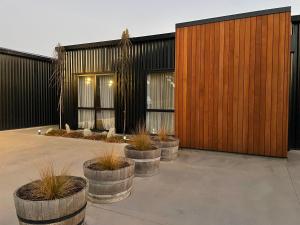 a building with five potted plants in front of it at Orchard Lodge Wanaka - Relax, Refresh, Recharge in Wanaka