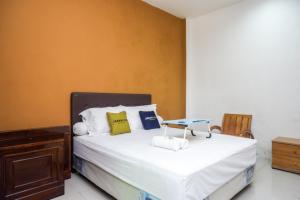 a bedroom with a bed with a table on it at Urbanview Hotel Blok O International in Yogyakarta