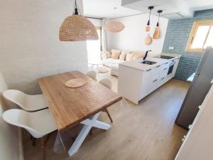 cocina y sala de estar con mesa de madera y sillas en PLAYMAR, en Cambrils