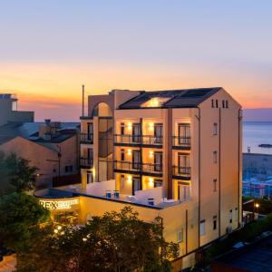 an apartment building with the sunset in the background at Rex Residence Hotel in Cattolica