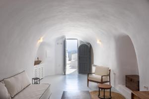 a living room with white walls and a black door at Oia Spirit Boutique Residences in Oia