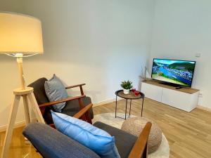 a living room with a couch and a tv at RiversideSuite.Mosel in Neumagen-Dhron
