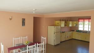a kitchen with yellow cabinets and a white refrigerator at Rain in Bridgetown