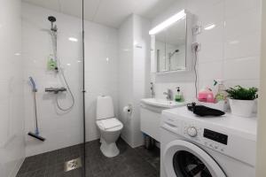 a bathroom with a washing machine and a toilet at Hiisi Homes Hämeenlinna Asemanranta in Hämeenlinna +49 photos