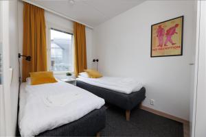 two beds in a small room with a window at Hiisi Homes Hämeenlinna Asemanranta in Hämeenlinna