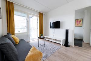 a living room with a couch and a window at Hiisi Homes Hämeenlinna Asemanranta in Hämeenlinna