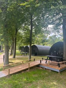 a camp site with awning and a table and trees at SportsPark Blaavandshuk Resort in Oksbøl