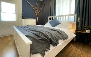 um quarto com uma cama branca e um cobertor cinzento em RiversideSuite.Mosel em Neumagen-Dhron