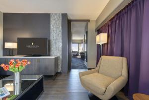 ein Wohnzimmer mit einem Stuhl und einem TV im Zimmer in der Unterkunft InterContinental St. Paul Riverfront, an IHG Hotel in Saint Paul