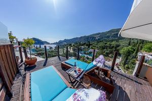a deck with chairs and tables and a view of the water at Tango Studios in Paleokastritsa