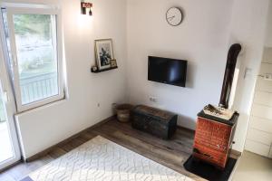 a living room with a fireplace and a tv at Idyllic river front holiday houses - Tišine in Goražde