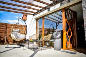 a patio with chairs and a table and a swing at Meru Minivilla in Szeged