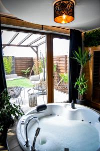 a bath tub in front of a window with a patio at Meru Minivilla in Szeged