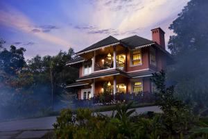 une maison dans les bois la nuit dans l'établissement Coorg Wilderness Resort & Spa, à Madikeri