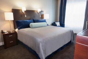 a hotel room with a large bed with blue pillows at Sandman Signature Langley Hotel in Langley