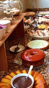 uma mesa com vários tipos diferentes de pastelarias em Pousada Condado Brasileiro em Campos do Jordão