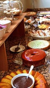 a table topped with lots of different types of pastries at Pousada Condado Brasileiro in Campos do Jordão