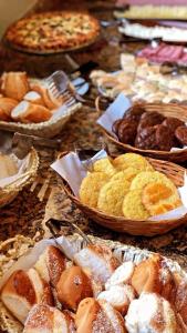 坎普斯杜若爾當的住宿－波薩達康達多布拉斯雷洛酒店，一张桌子,上面放着许多不同类型的糕点和馅饼