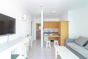 a living room with a couch and a kitchen at Flatguest Alisios Playa 4 in Corralejo