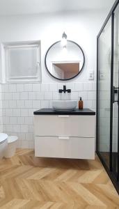a bathroom with a sink and a mirror at Village Mielno - najpiękniejsze domki wakacyjne nad morzem in Mielno