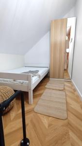 mały pokój z łóżkiem i lustrem w obiekcie Village Mielno - najpiękniejsze domki wakacyjne nad morzem w mieście Mielno