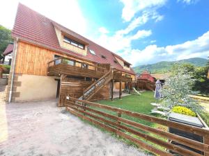 une maison en bois avec une clôture devant elle dans l'établissement L'escale de la tour, à Breitenbach