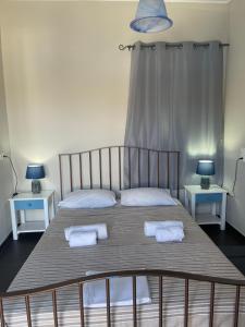 a bedroom with a bed with two towels on it at AEGEAN VIEW SEASIDE ROOMS AND STUDIOS KEA in Korissia