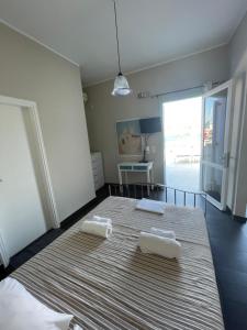 a bedroom with a bed with two towels on it at AEGEAN VIEW SEASIDE ROOMS AND STUDIOS KEA in Korissia