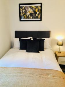 een bed met zwart-witte kussens in een slaapkamer bij Cloud9SA at Woking Central in Woking