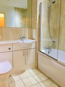 a bathroom with a sink and a shower and a toilet at Cloud9SA at Woking Central in Woking