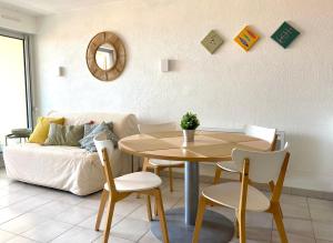ein Wohnzimmer mit einem Tisch und einem Sofa in der Unterkunft Escale paisible à Sète, belle terrasse vue sur mer in Sète